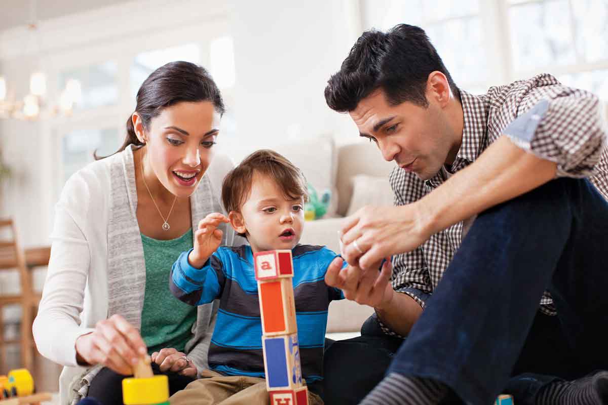 Aspirational photography of parents playing blocks with their son on the floor